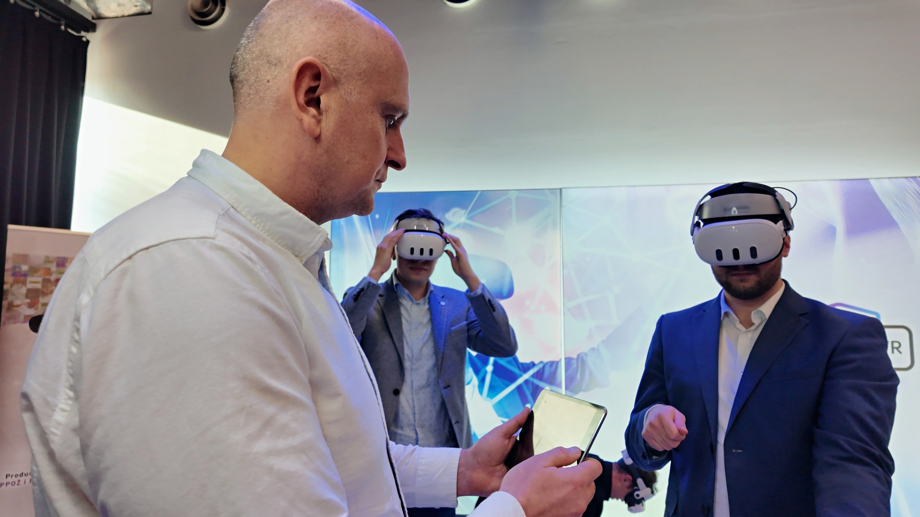 A trainer with a tablet following participants in VR headsets