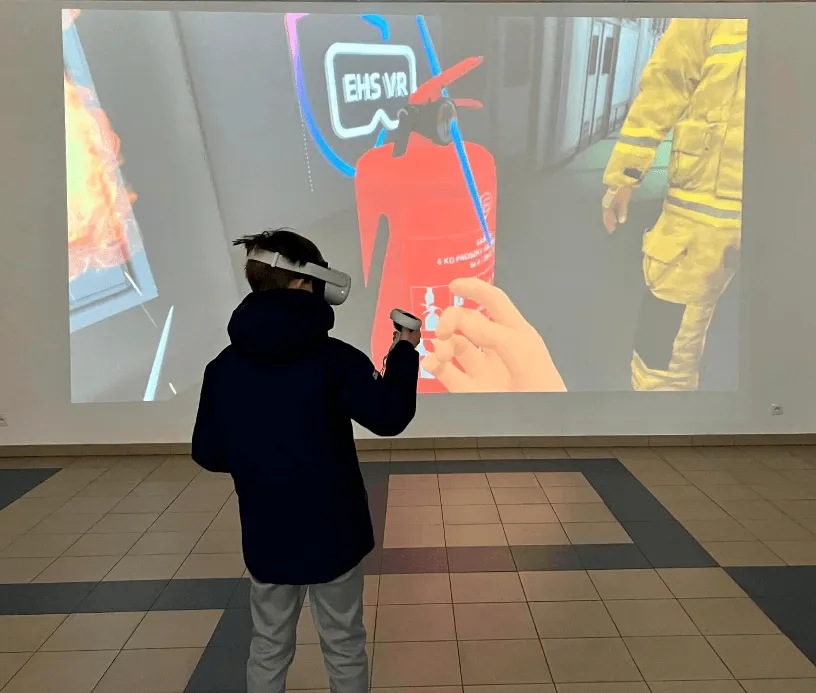 Ein Kind mit VR-Brille vor einer Wandprojektion des VR-Brandschutzszenarios