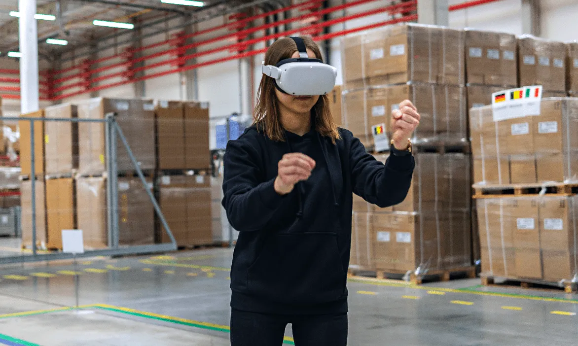 Une femme travaille dans une usine et suit une formation SST avec un casque VR dans un environnement virtuel réaliste.