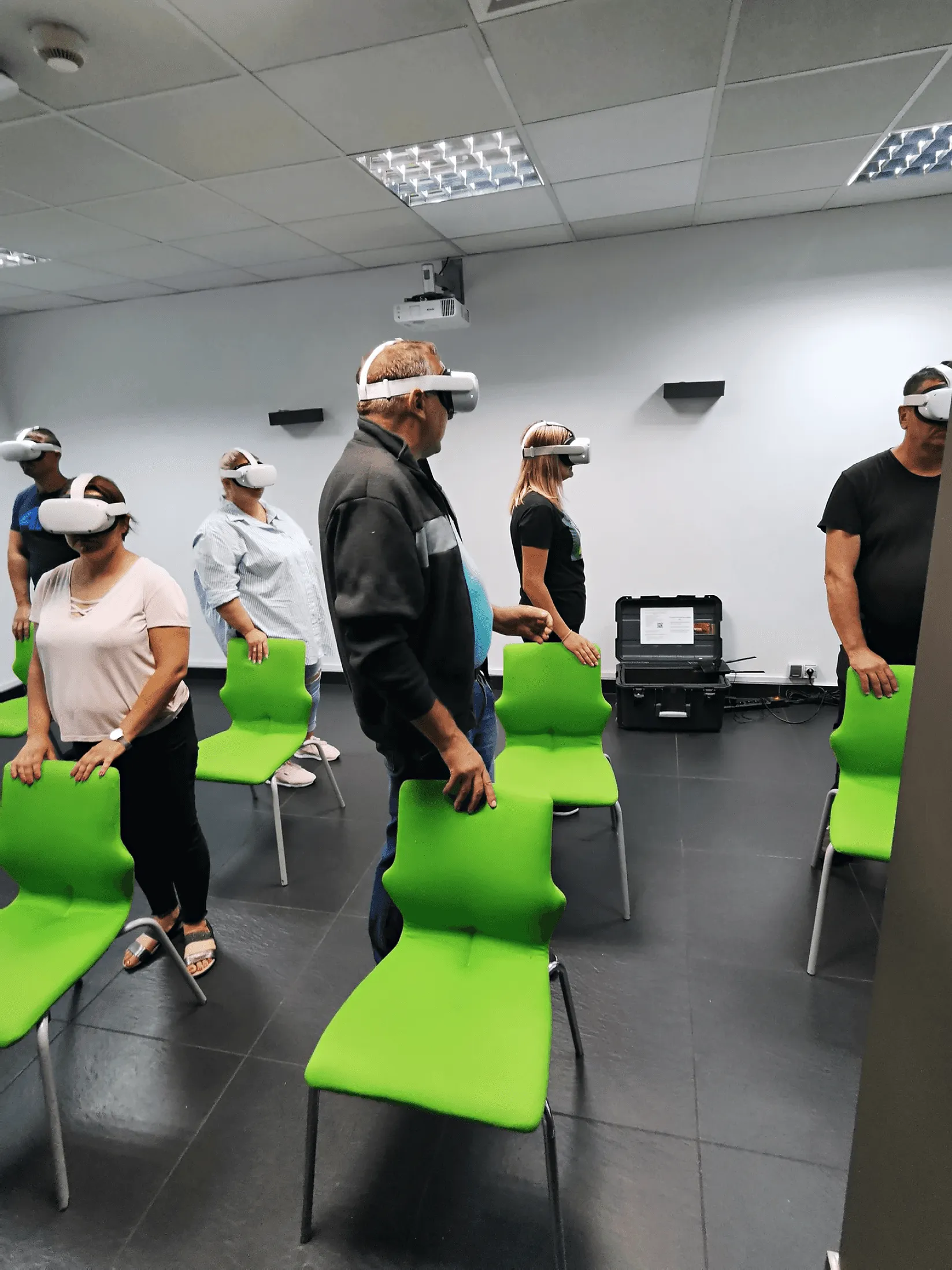 Uczestnicy w goglach VR stoją za krzesłami podczas szkolenia LOTO