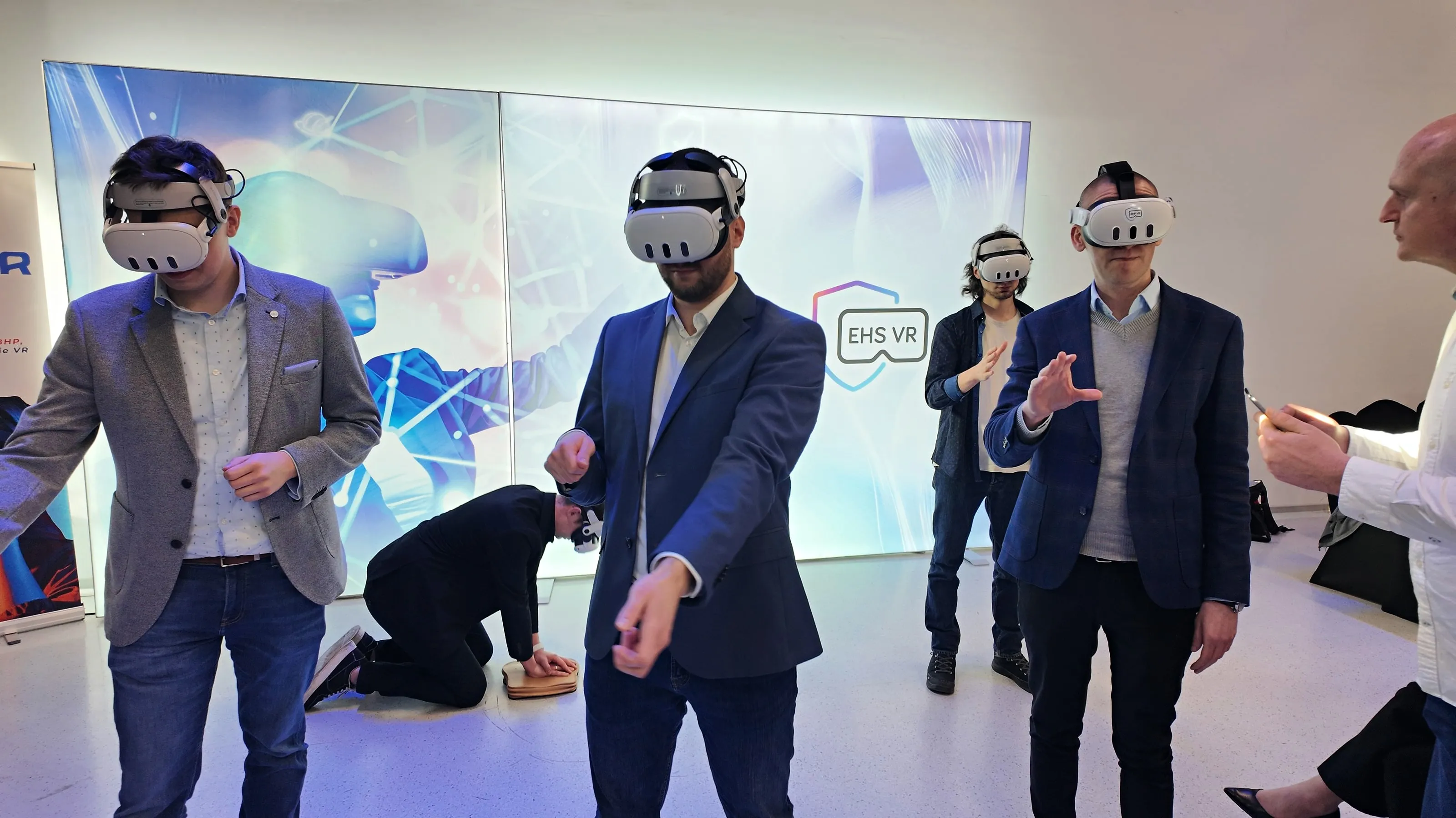 A group trains in VR headsets while one participant practises CPR on a mannequin