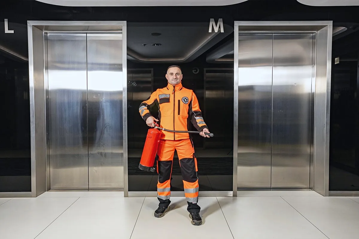 A rescuer in an orange suit standing by the elevators