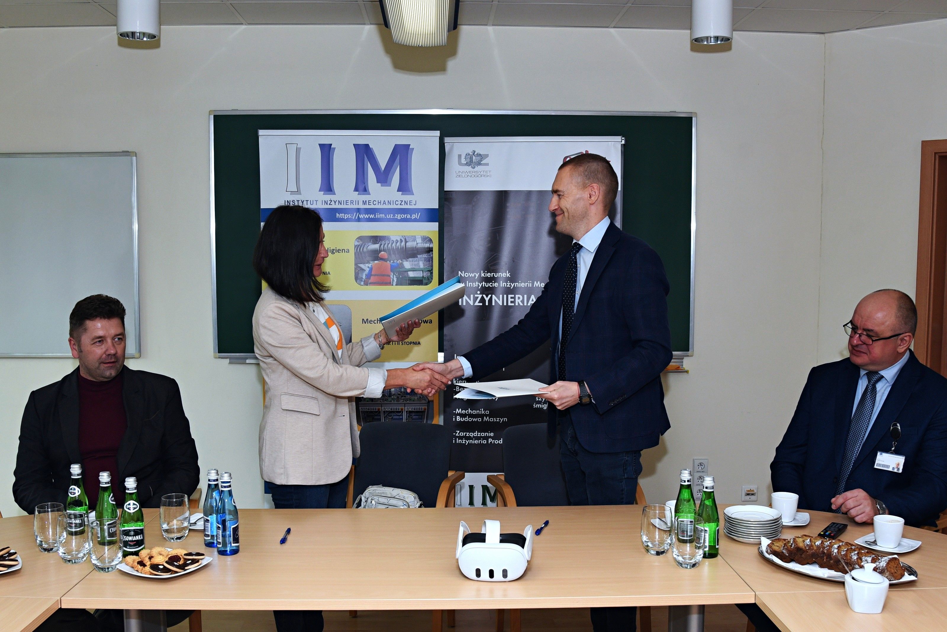 Signing an agreement with the University of Zielona Góra, with a VR headset on the table