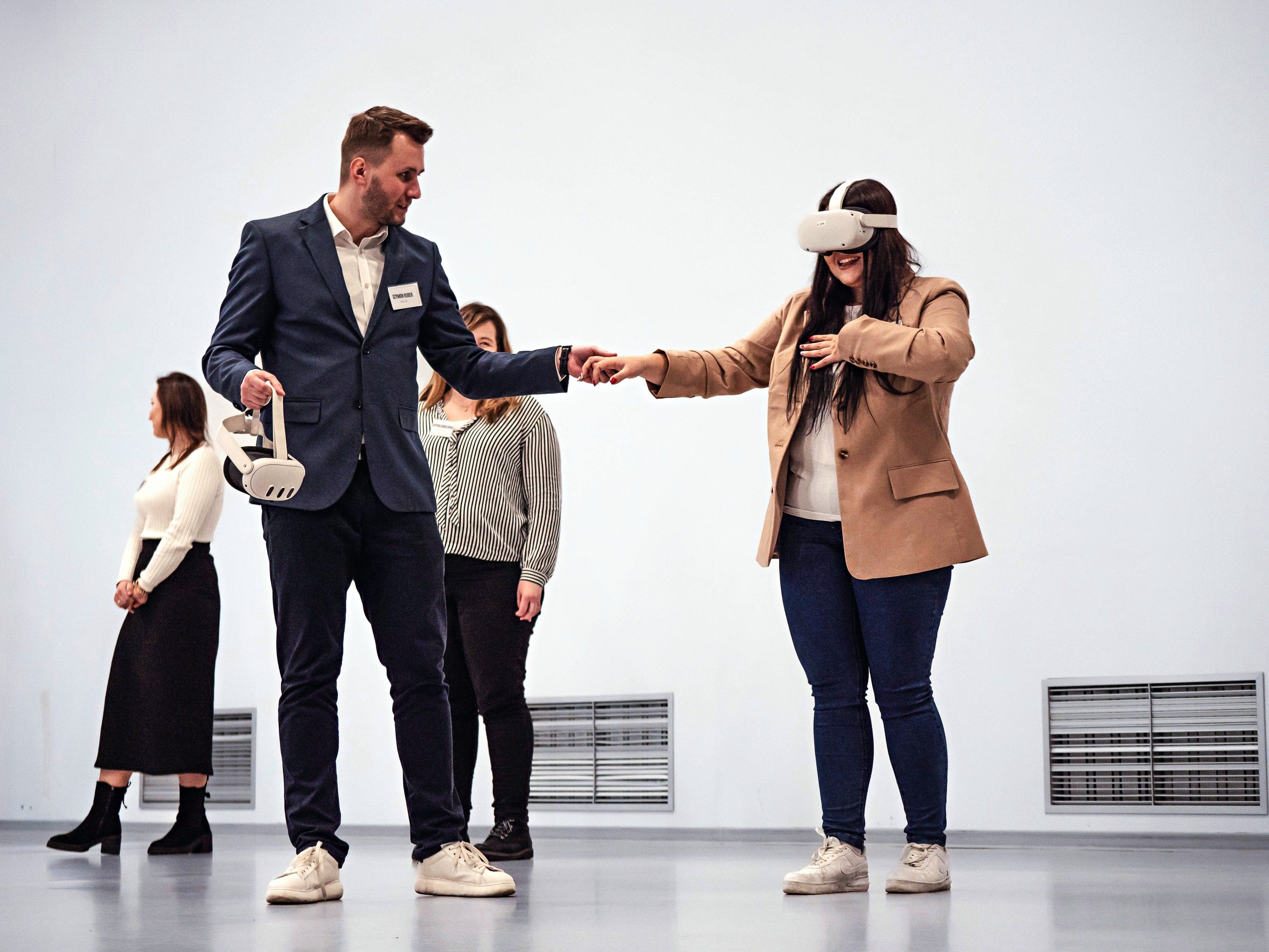 A participant in a VR headset repeats a procedure while the trainer follows her moves