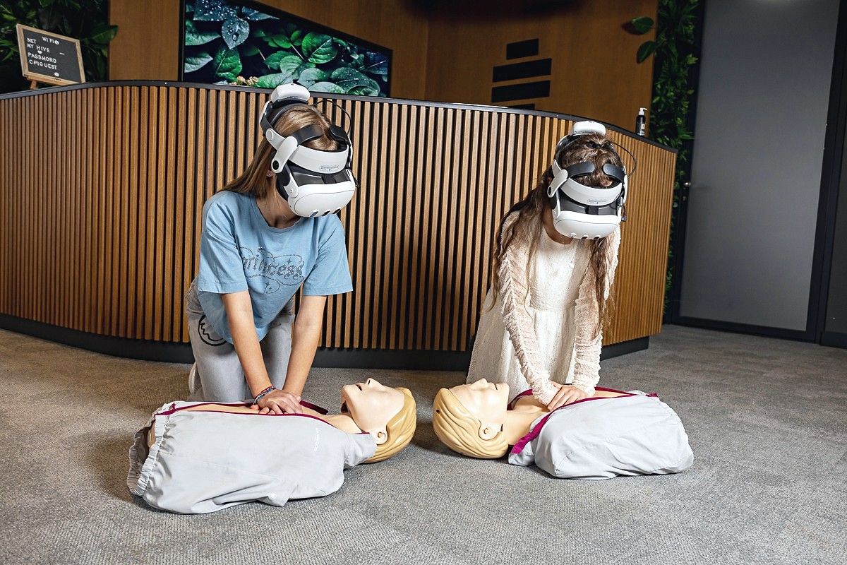 Dzieci w goglach VR ćwiczą resuscytację na fantomach