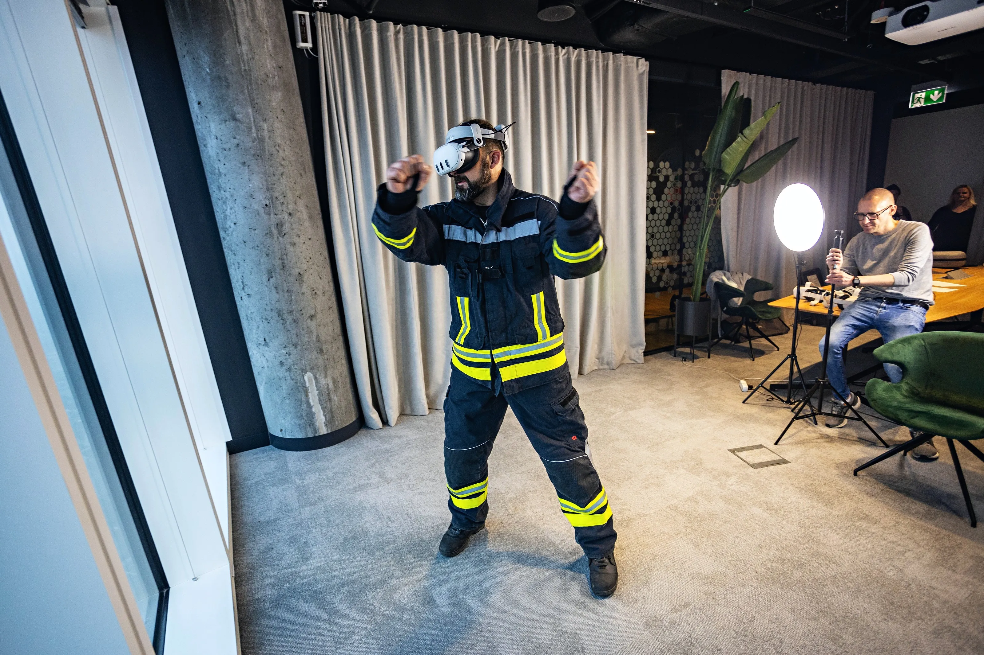 A firefighter in turnout gear trains in a VR headset