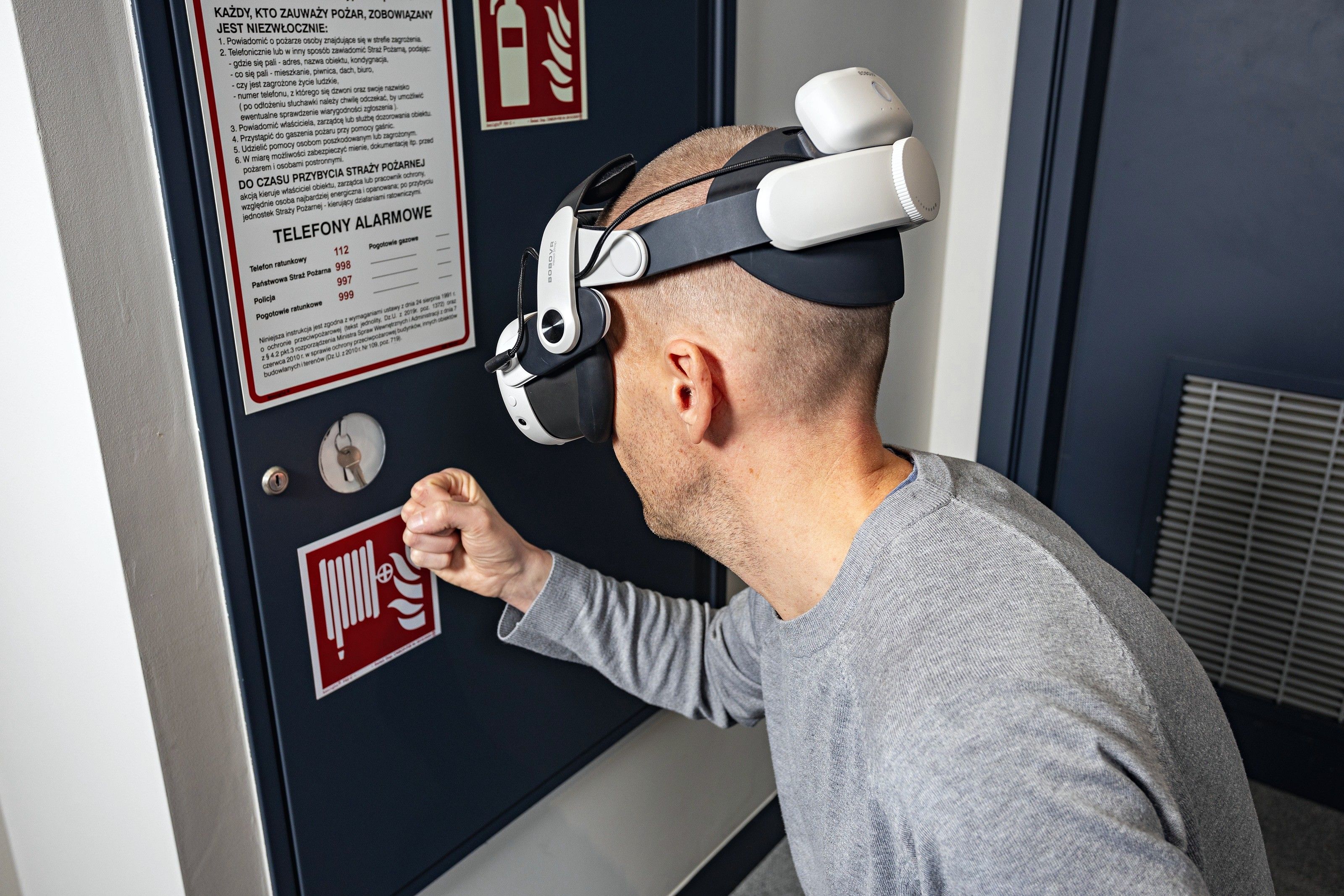 Ein Teilnehmer mit VR-Brille drückt einen Handfeuermelder
